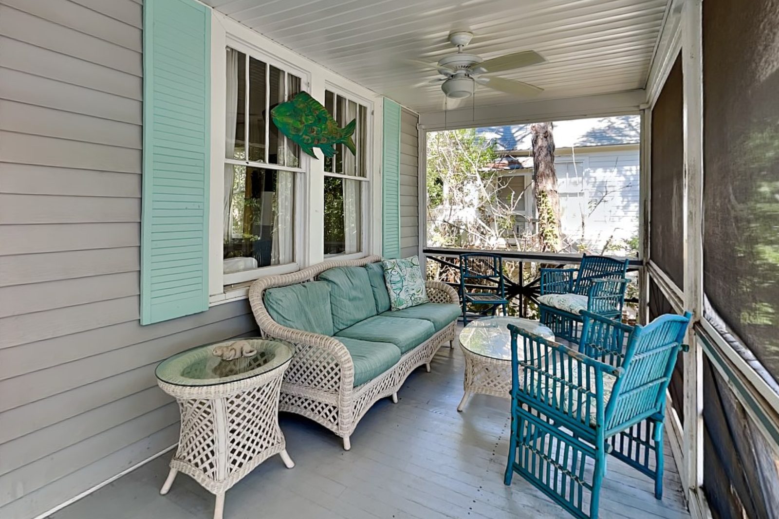 Second screened porch with wicker seating and aqua shutters